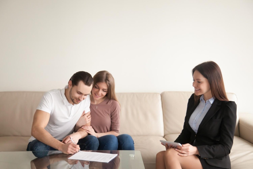 couple signing documents with an agent during overseas property investment consultation