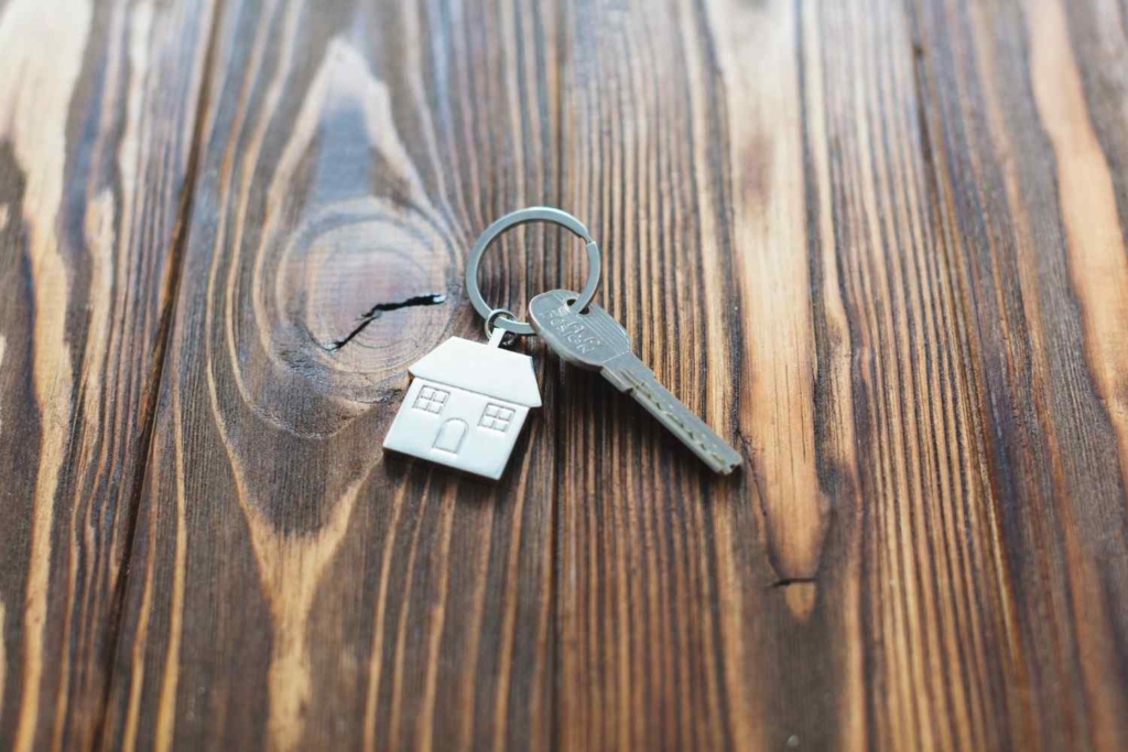 house key with home keychain on a wooden table for overseas property investment