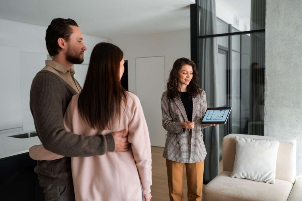 agent showing property plans to buyers as part of international real estate marketing in portugal.