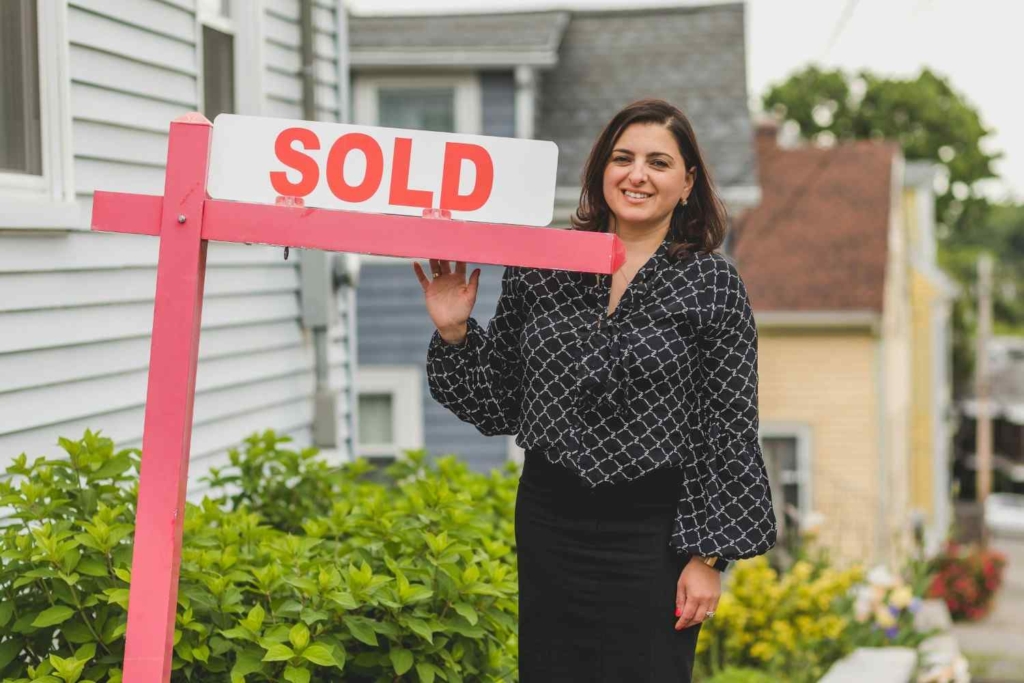 real estate agent holding a sold sign, showing success in selling overseas property in portugal.