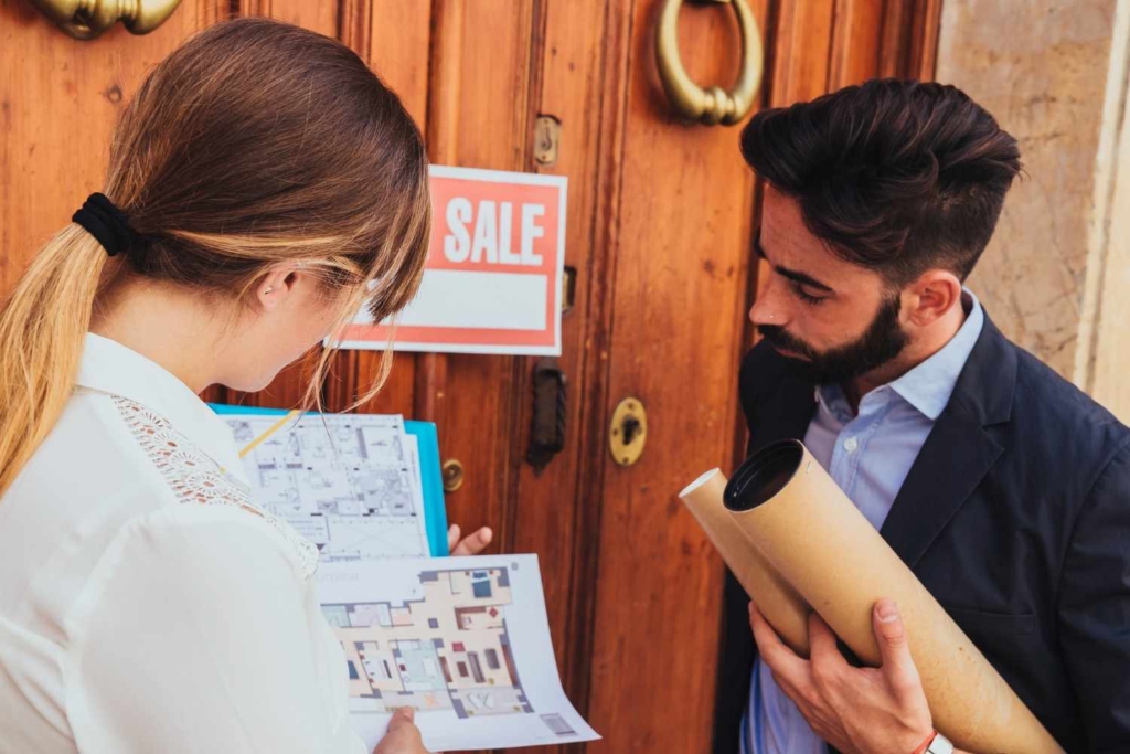 agents discussing floor plan details to sell international property online.