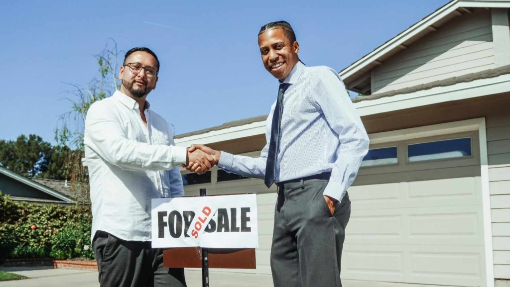 two people shaking hands after a home sale as part of international real estate investing.