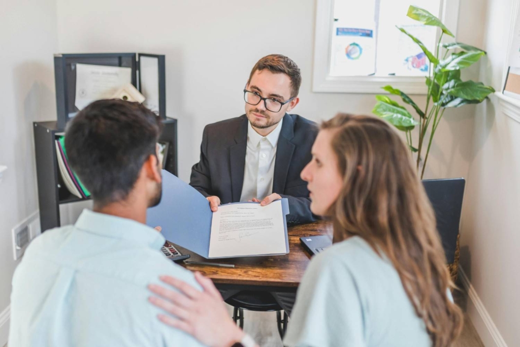 couple reviewing documents with an agent during international property marketing in portugal.