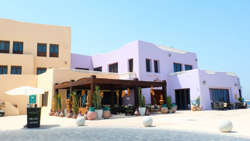 modern pastel-colored building with outdoor seating in qatar