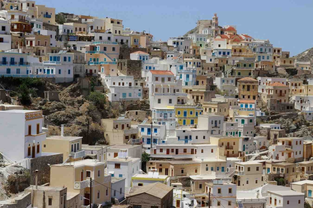 colorful hillside homes showing traditional architecture, ideal for buying a house in greece.