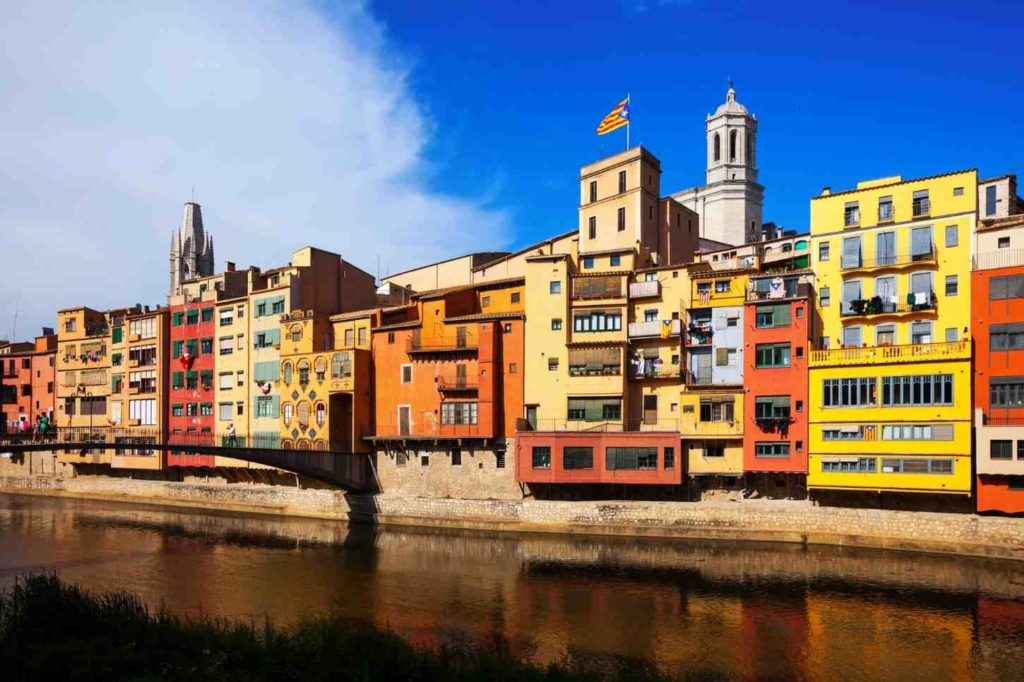 colorful riverside homes showing different types of properties for sale in spain.