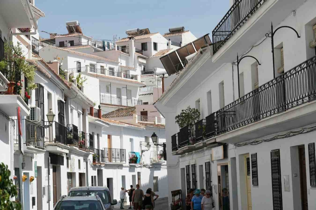 white hillside street in frigiliana, spain with traditional homes and balconies