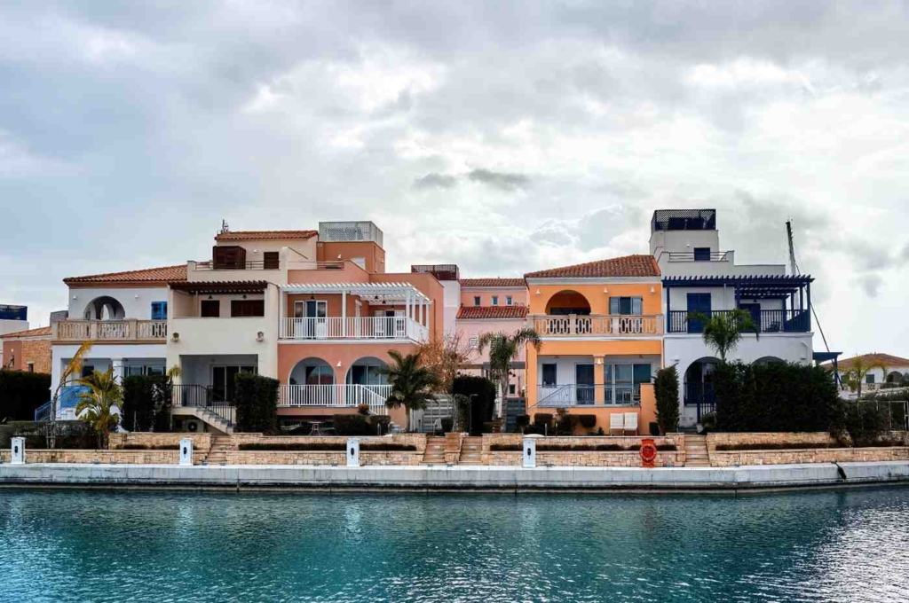 affordable housing in greece along a calm waterfront with colorful coastal homes
