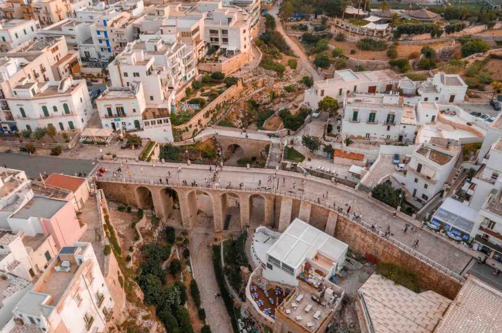 affordable housing in greece overlooking a scenic hillside town with stone bridge