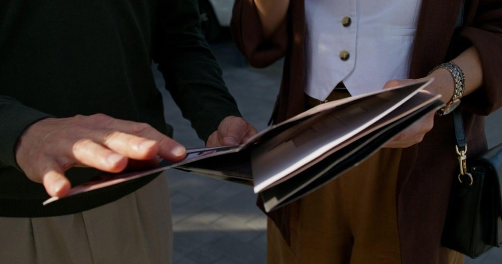 real estate agent presenting real estate brochure content to potential buyer.